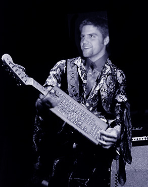 Poorly photoshopped image of Ben's face atop a generic rockstar, with a computer keyboard instead of a guitar
